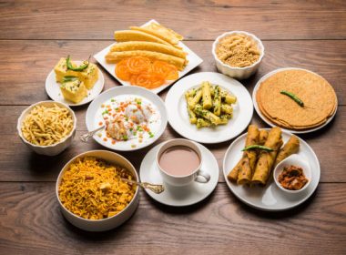 Group of Gujarati snacks like jalebi-fafda, thepla, khaman dhokla, aloo bhujiya, khandvi,khakra, dahi vada, gathiya with hot tea